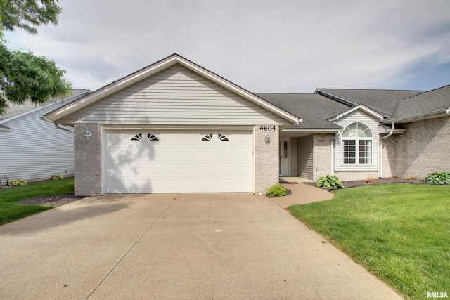 4804 Elm St, Quincy, IL 62305 - ranch-style house with brick siding, concrete driveway, an attached garage, and a front lawn