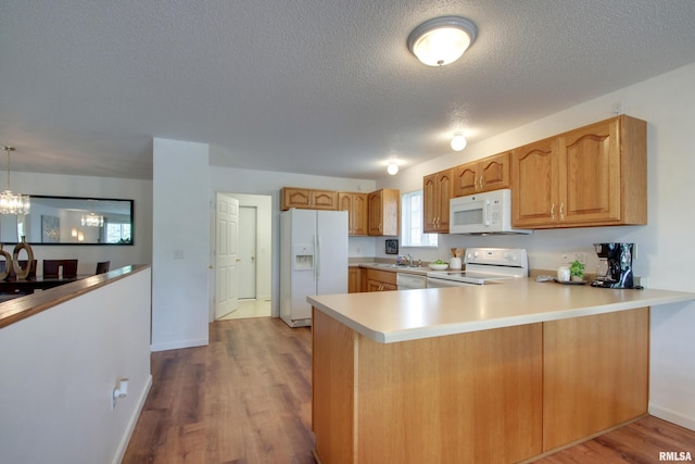 4804 Elm St, Quincy, IL 62305 - kitchen with white appliances, a peninsula, a textured ceiling, a sink, and light countertops