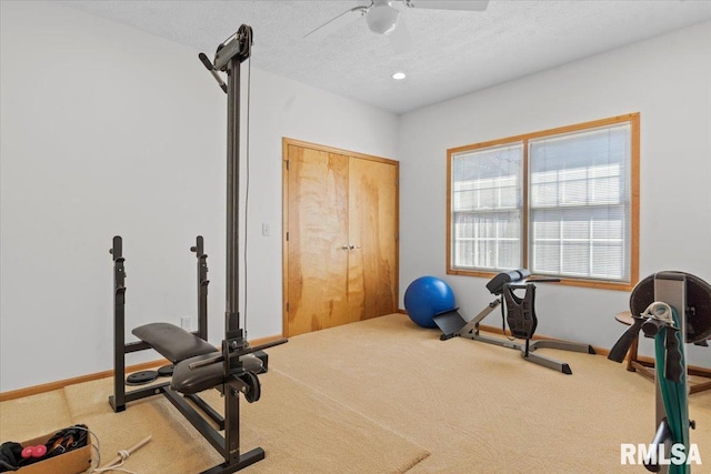 workout area featuring a ceiling fan, carpet, baseboards, and a textured ceiling