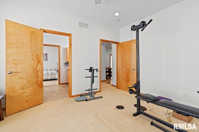 exercise area featuring baseboards, visible vents, and carpet