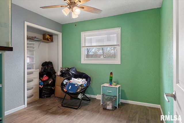 bedroom with baseboards, ceiling fan, and wood finished floors