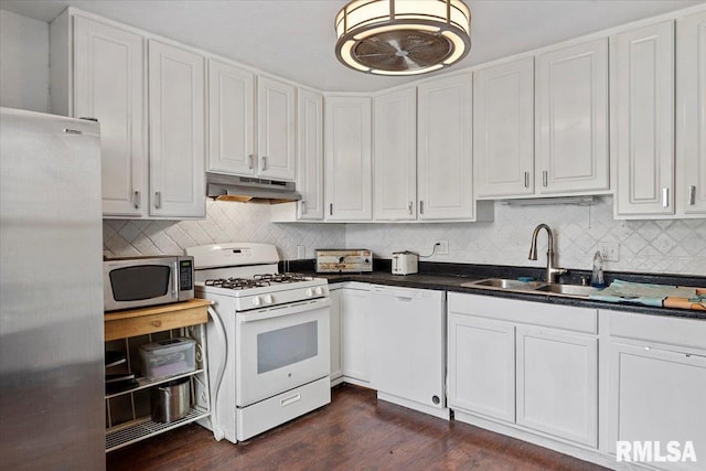 kitchen with a sink, under cabinet range hood, stainless steel appliances, dark countertops, and white cabinets