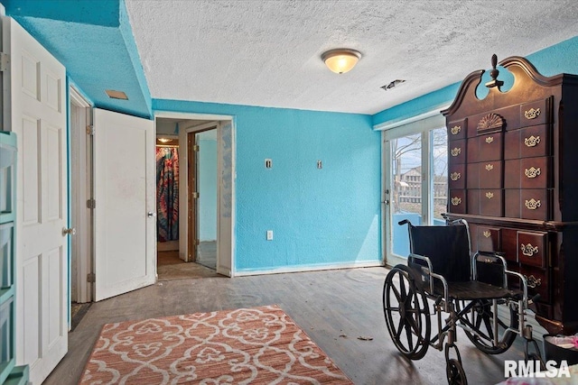 bedroom with access to exterior, wood finished floors, a textured ceiling, baseboards, and a textured wall