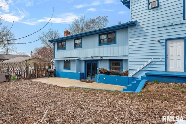 back of house featuring a patio, fence, and a chimney