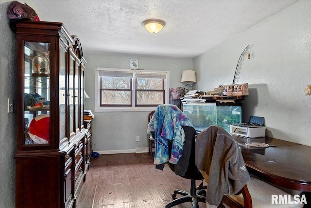 office space with wood-type flooring, baseboards, and a textured ceiling