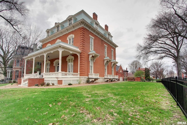 1477 Maine St, Quincy, IL 62301 - view of side of home with fence, covered porch, mansard roof, and a lawn