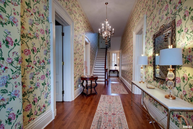 1477 Maine St, Quincy, IL 62301 - hallway with stairs, wood finished floors, baseboards, wallpapered walls, and an inviting chandelier