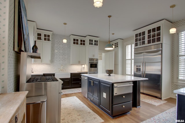 1477 Maine St, Quincy, IL 62301 - kitchen with white cabinetry, a warming drawer, light wood-type flooring, stainless steel appliances, and wallpapered walls