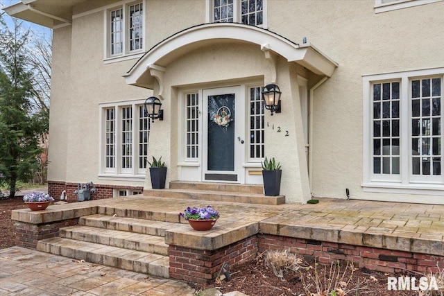 view of exterior entry featuring stucco siding and french doors