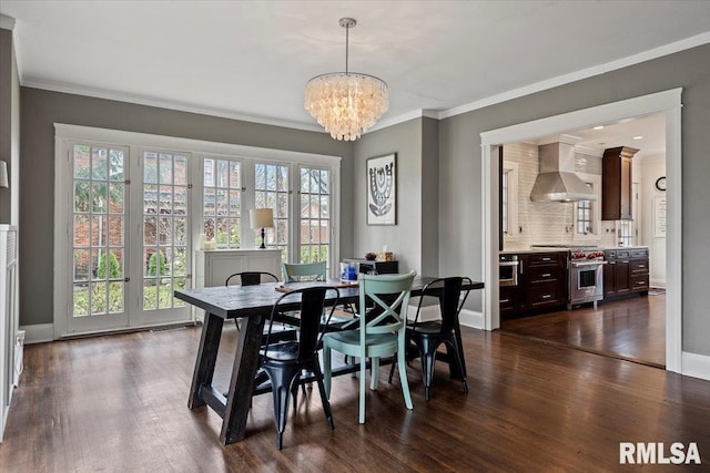 dining room featuring a chandelier, dark wood-type flooring, crown molding, and baseboards