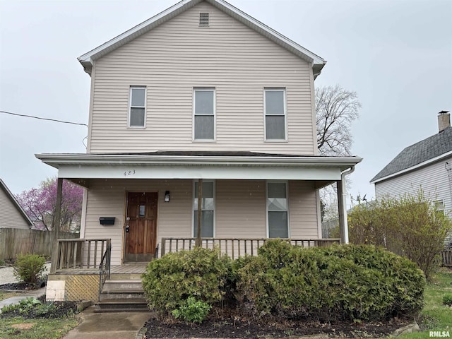 view of front of property featuring fence and a porch