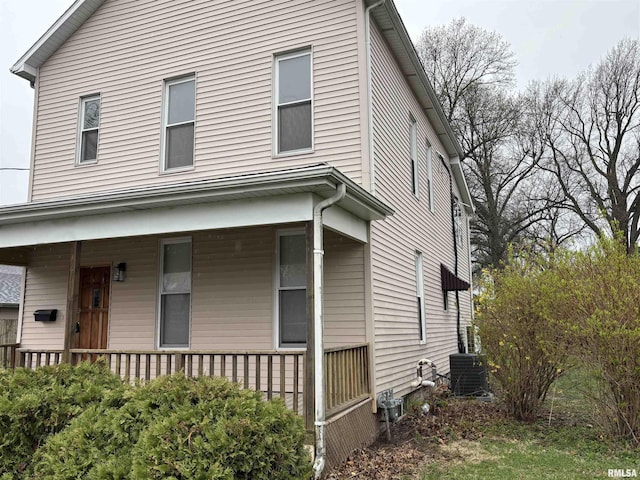 view of side of property featuring covered porch and cooling unit