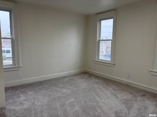 carpeted empty room featuring baseboards