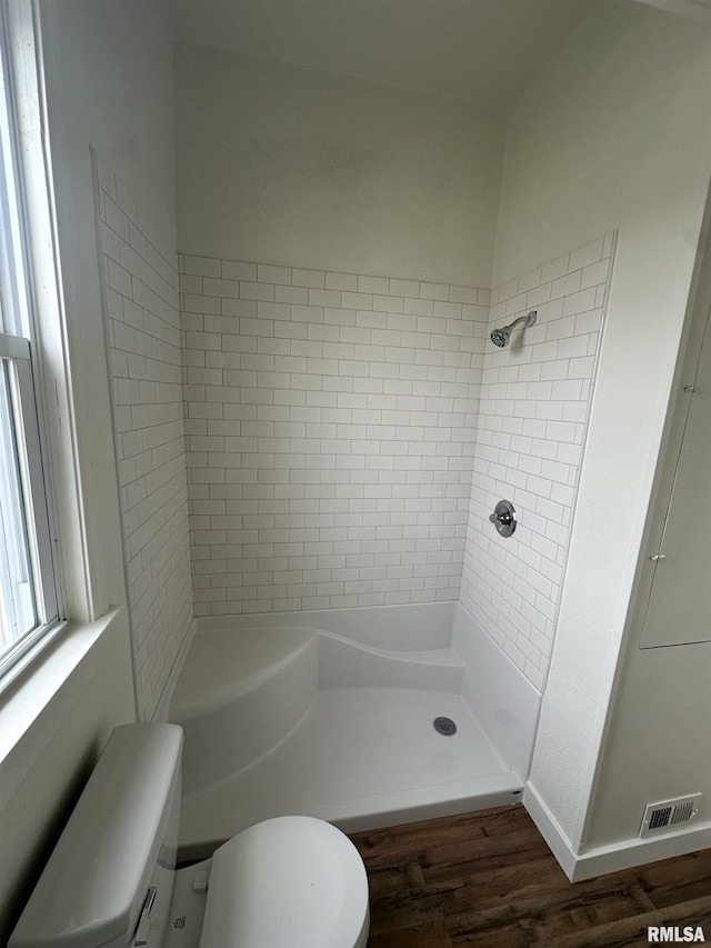 bathroom with toilet, visible vents, wood finished floors, and a shower stall