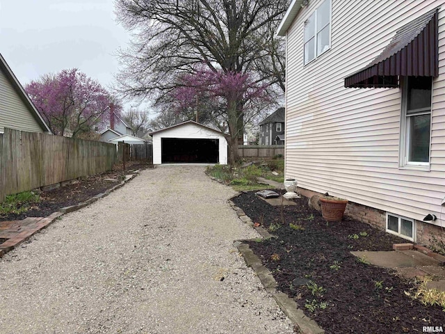 view of side of property featuring an outdoor structure, fence, and a garage