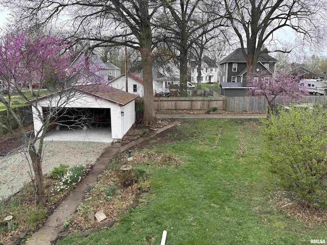 view of yard featuring a residential view, an outbuilding, a garage, and fence