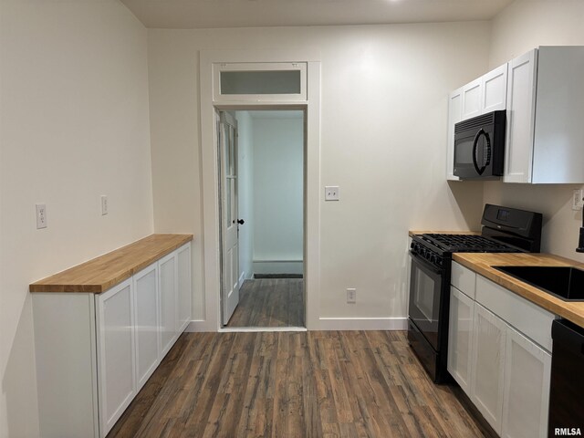 kitchen featuring a sink, white cabinets, dark wood-style floors, butcher block counters, and black appliances