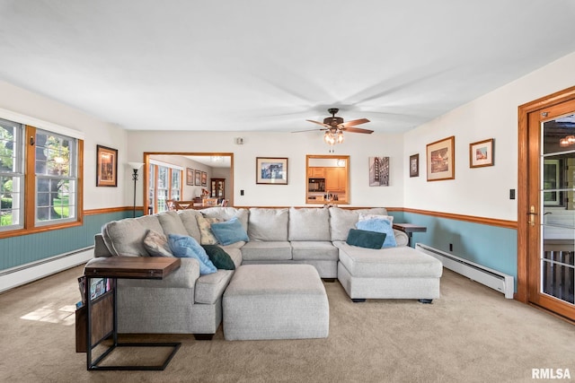 carpeted living room featuring ceiling fan, a baseboard heating unit, wainscoting, and a baseboard radiator