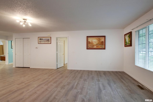 812 N 49th St, Quincy, IL 62305 - spare room featuring plenty of natural light, light wood-style floors, and a textured ceiling