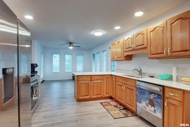 812 N 49th St, Quincy, IL 62305 - kitchen featuring appliances with stainless steel finishes, a peninsula, light wood-style floors, ceiling fan, and a sink