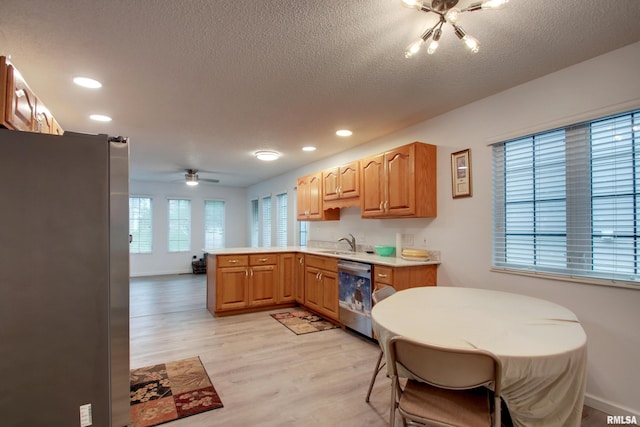 812 N 49th St, Quincy, IL 62305 - kitchen featuring a peninsula, light countertops, light wood-style floors, stainless steel appliances, and a sink