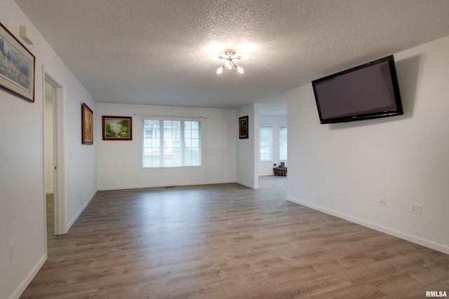 812 N 49th St, Quincy, IL 62305 - unfurnished living room with a textured ceiling, wood finished floors, and baseboards