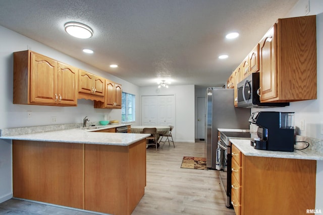 812 N 49th St, Quincy, IL 62305 - kitchen featuring a sink, light countertops, a peninsula, a textured ceiling, and stainless steel appliances