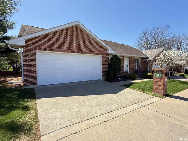 104 W Waterford Dr, Quincy, IL 62305 - view of front of home featuring concrete driveway, roof with shingles, brick siding, and a garage