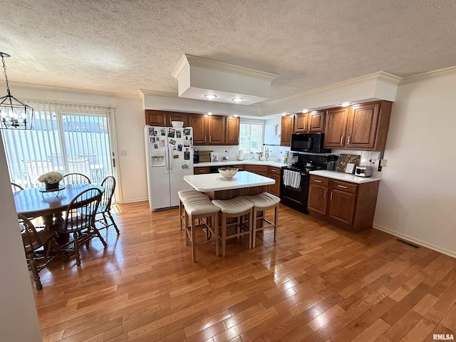 104 W Waterford Dr, Quincy, IL 62305 - kitchen with light wood-style flooring, light countertops, black appliances, and a wealth of natural light