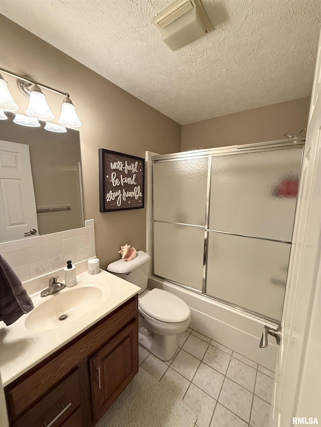 104 W Waterford Dr, Quincy, IL 62305 - full bathroom featuring shower / bath combination with glass door, vanity, tile patterned flooring, a textured ceiling, and toilet
