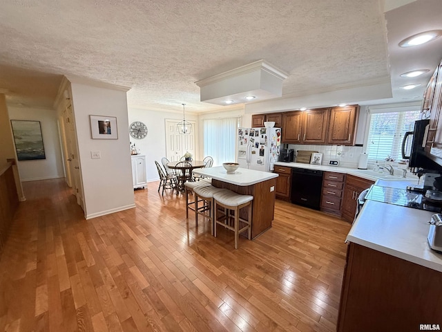 104 W Waterford Dr, Quincy, IL 62305 - kitchen with light countertops, light wood-style floors, a breakfast bar, and black appliances