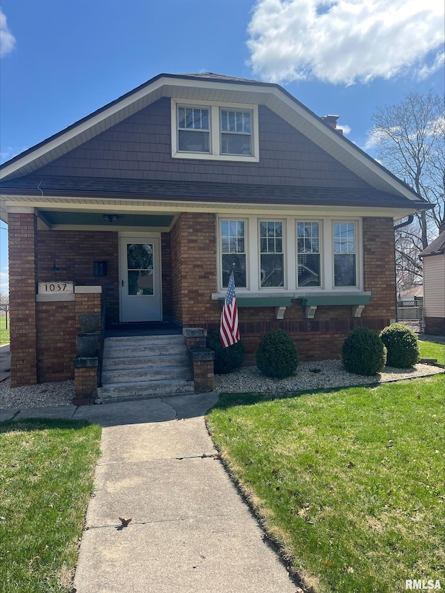 1037 Brown Ave, Galesburg, IL 61401 - view of front of house featuring a front yard, brick siding, and covered porch