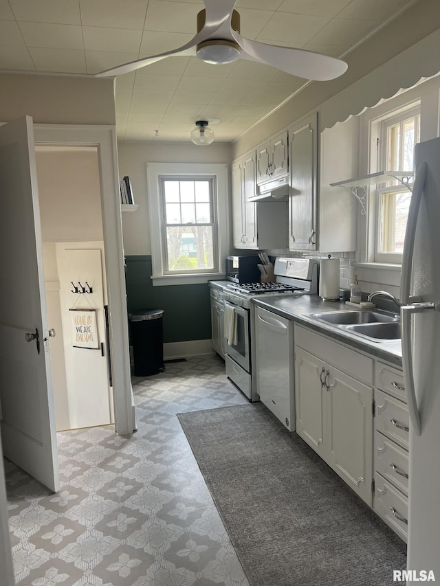 1037 Brown Ave, Galesburg, IL 61401 - kitchen featuring a wealth of natural light, under cabinet range hood, white appliances, and a sink
