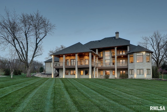 2300 Greenspointe Cir, Quincy, IL 62301 - rear view of house featuring a lawn, stone siding, a balcony, and a chimney