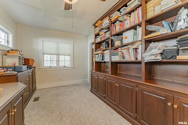 office space with visible vents, a wealth of natural light, ceiling fan, and baseboards