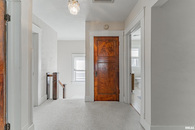 corridor featuring carpet flooring, plenty of natural light, and an upstairs landing