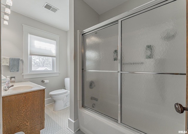 bathroom featuring visible vents, toilet, combined bath / shower with glass door, and vanity