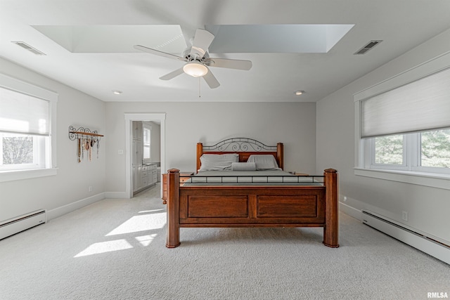 bedroom with visible vents, multiple windows, light colored carpet, and baseboard heating