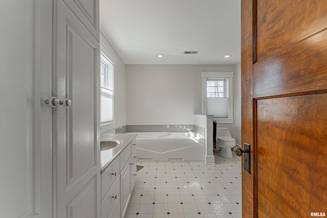 full bathroom with a garden tub, vanity, visible vents, toilet, and tile patterned floors