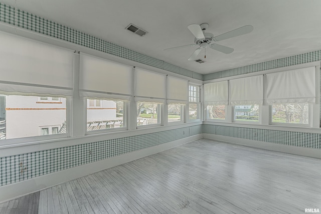 unfurnished sunroom featuring visible vents and hardwood / wood-style flooring