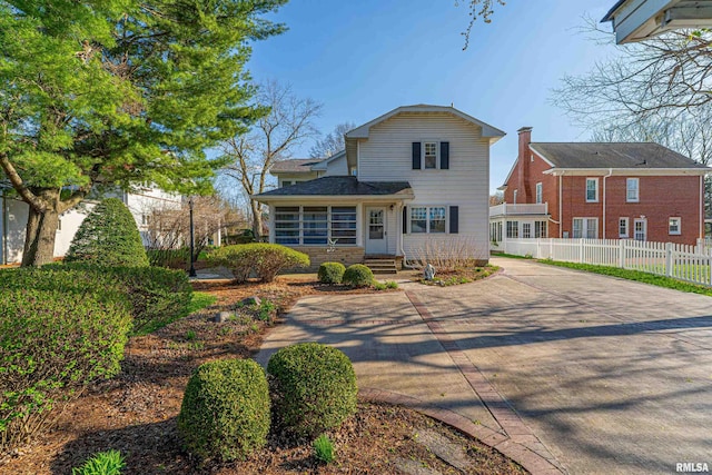 view of front of house featuring fence and concrete driveway