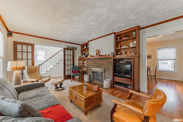 living room featuring baseboards, crown molding, and wood finished floors