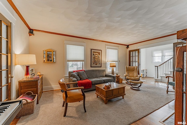 living room with baseboards, ornamental molding, a textured ceiling, stairs, and wood finished floors