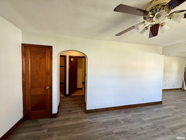424 Lashmett Ct, Rushville, IL 62681 - unfurnished room with arched walkways, baseboards, wood finished floors, and a ceiling fan