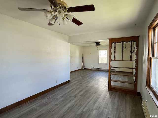 424 Lashmett Ct, Rushville, IL 62681 - unfurnished room featuring baseboard heating, ceiling fan, wood finished floors, and baseboards