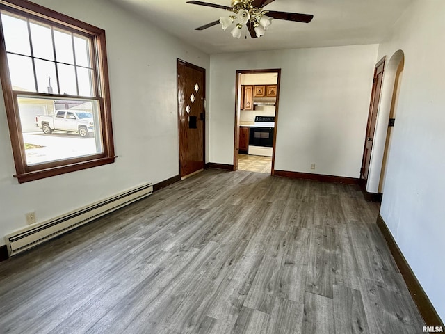 424 Lashmett Ct, Rushville, IL 62681 - spare room with a baseboard radiator, arched walkways, a ceiling fan, wood finished floors, and baseboards