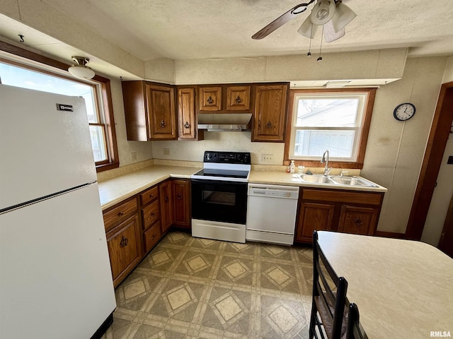 424 Lashmett Ct, Rushville, IL 62681 - kitchen featuring white appliances, under cabinet range hood, a sink, brown cabinets, and a textured ceiling