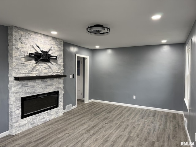 unfurnished living room with visible vents, baseboards, a fireplace, recessed lighting, and wood finished floors