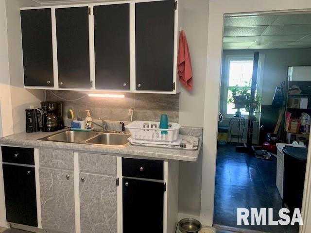 kitchen featuring backsplash, a sink, and light countertops