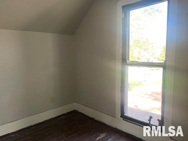 additional living space with lofted ceiling, baseboards, and dark wood-style floors